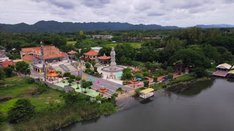 Buddhist Statue Along the River Kwai | Thailand | 4K Drone Aerial Stock Footage 322823918