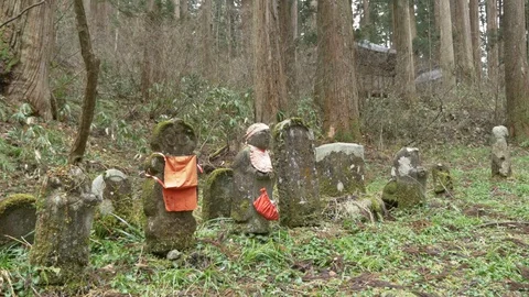 Buddhist statue with clothes in a graveyard at Mt. Haguro Stock Footage 128282690