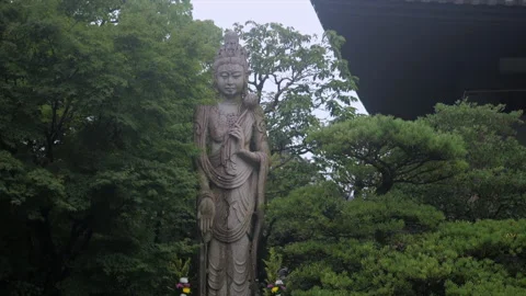 Buddhist Stone Statue in Kyoto Temple Garden Surrounded by Lush Green Trees Stock Footage 342676113