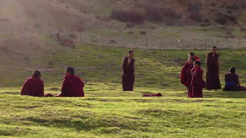 Buddhist students resting from prayers and study, playing badminton Stock Footage 149937170