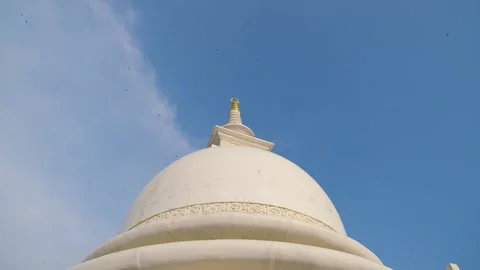 Buddhist stupa. In the background are blue skies and flying birds Stock Footage 233557520