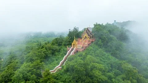 Buddhist Temple Architecture Surrounded By Lush Misty Hills In Phrae Thaila.. Stock Photos