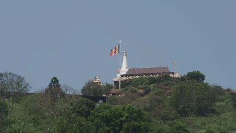 Buddhist temple flag waving on a green hilltop Stock Footage 340642863