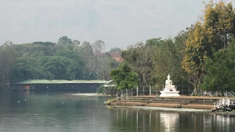 Buddhist White Statue on the River Kwai in Thailand with a Bridge in the Stock Footage 330879282