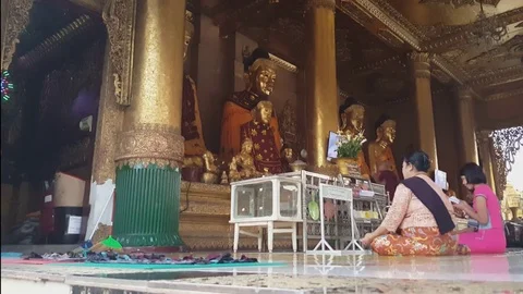 Buddhists pray in front of Buddha statues Shwedagon Pagoda, monk walks, Yangon Видео 78058577