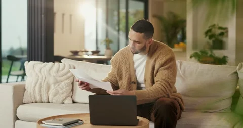 Budget, documents and laptop with man on sofa in home living room for finance or Stock Footage 335265267