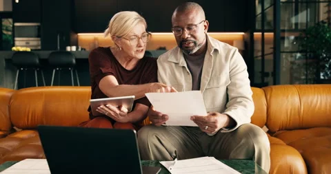 Budget, documents and tablet with interracial couple on sofa in home living room Stock Footage 337922048