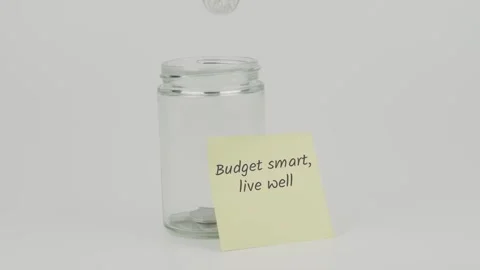 Budget smart live well text or word on yellow notes on empty jar hand insert Stock Footage 307064933