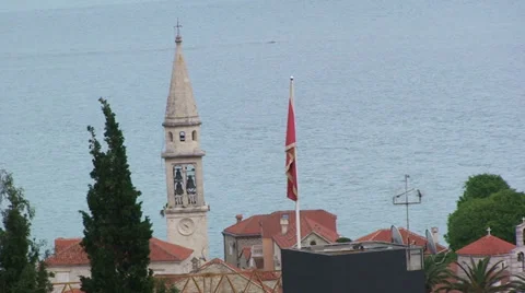 Budva belfry tower and flag of Montenegro Stock Footage 33349716