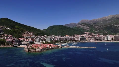 Budva Old Town perched on Adriatic coastline seen from drone with blue sky Stock Footage 336581744
