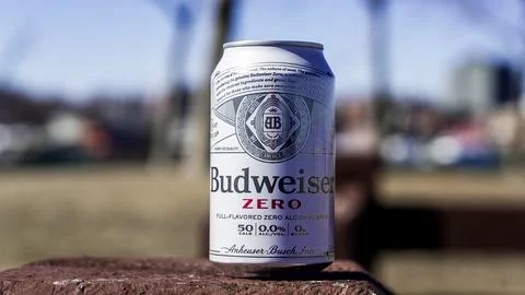 Budweiser Zero can resting on a stone with a blurred urban backdrop on a su.. Stock Photos