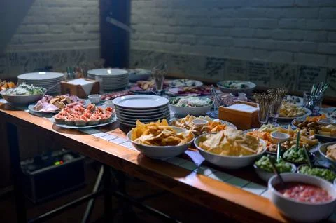 A buffet of appetizers, chips, dips, salads and cold cuts Stock Photos
