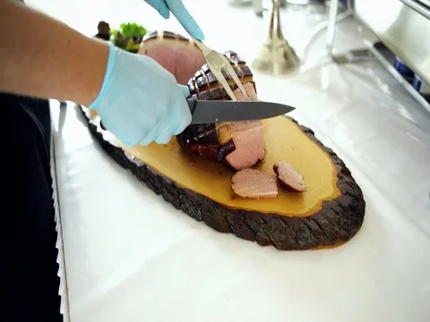 Buffet: the chef cuts the meat Stock Footage 77980058
