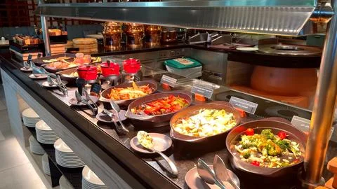 Buffet featuring roasted vegetables in cast iron plates rich gravies and Stock Photos