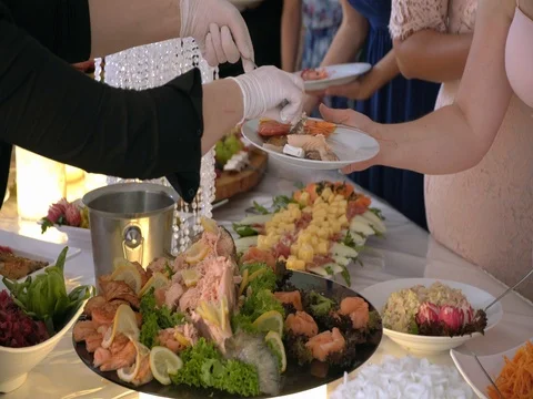 Buffet guests put food in the dish Stock Footage 78520294