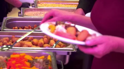 Buffet guests putting food on plates Stock Footage 277436813