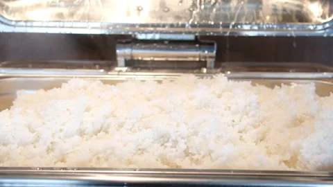 Buffet rice tray Close up serving spoon scooping fluffy rice from buffet tray at Stock Footage 316174184