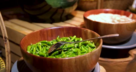 At buffet, serve green hot pepper in a wooden bowl. Small peppers are scooped Stock Footage 286049169