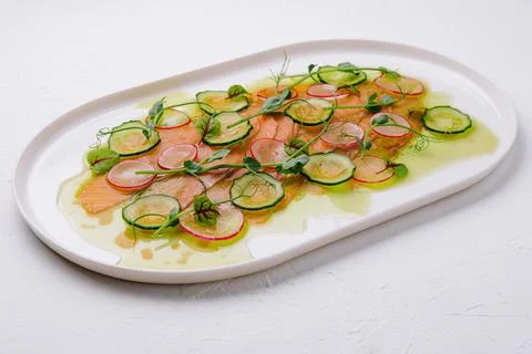 Buffet serving of pickled salmon slices with radish, cucumber Stock Photos