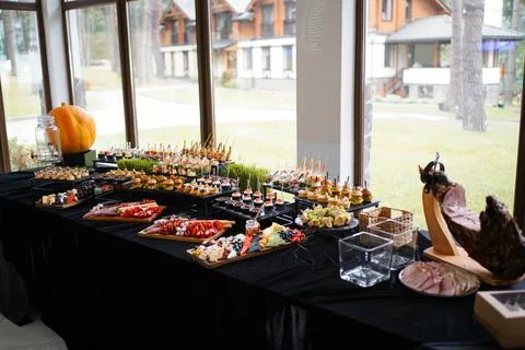 Buffet table with appetizers, cheese platters and mini burgers at a wedding c Stock Photos