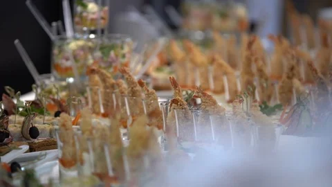 On the buffet table are festive snacks in glass glasses, shrimp in batter,  Stock Footage 103341680