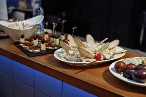 Buffet table with assorted cold snacks, including canapes on skewers on a slate Stock Photos