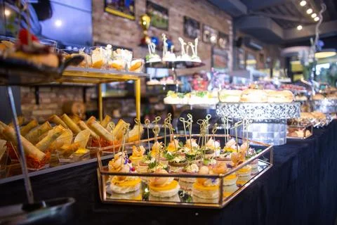 Buffet table with a black tablecloth with various snacks and treats catering Stock Photos
