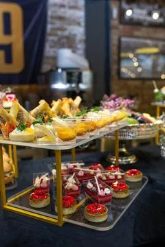 Buffet table with a black tablecloth with various snacks and treats catering Stock Photos