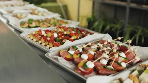 Buffet table for catering in a street cafe. Trays with appetizers of meat, fruit Stock Footage 318064552