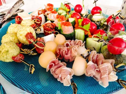 Buffet table. Many different snacks on skewers are on the plate. Stock Photos