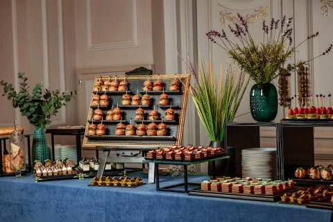Buffet table of mini cakes and burgers Stock Photos