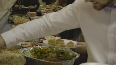 Buffet table. People making plates. Close up on hands. Stockbeeldmateriaal 123884208