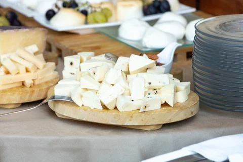 Buffet table presenting variety of delicious cheeses with grapes and bread 库存照片