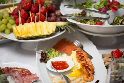 Buffet table of reception with cold snacks, shrimp, fish, caviar Stock Photos