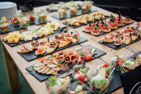 Buffet table of reception with cold snacks, meat and salads Stock Photos