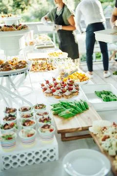 Buffet table of reception with cold snacks, meat and salads Stock Photos