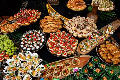 Buffet table of reception with cold snacks, meat, and salads. Top view. Stock Photos