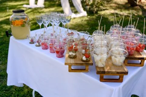 A buffet table with snacks in plastic cups and lemonade Stock Photos