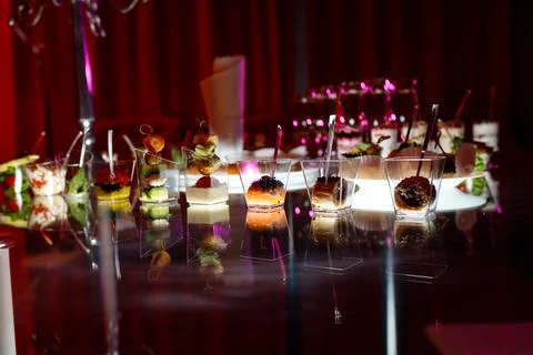 Buffet table with toasts and snacks and desserts in red tones Stock Photos