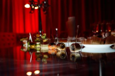 Buffet table with toasts and snacks and desserts in red tones Stock Photos