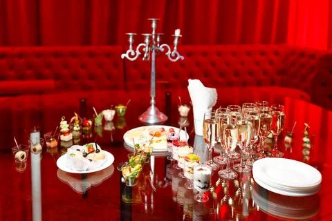 Buffet table with toasts and snacks and desserts in red tones Stock Photos