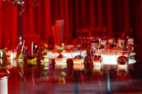 Buffet table with toasts and snacks and desserts in red tones Stock Photos