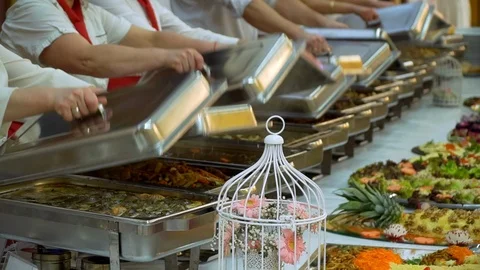 Buffet table: waiters open hot dishes Video stock 88360863