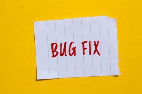 Bug fix message written on ripped torn white paper piece with yellow backgrou Foto stock
