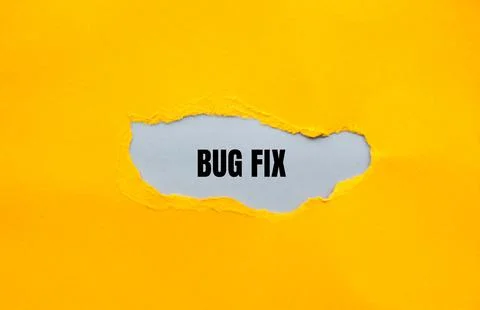 Bug fix message written on ripped yellow torn paper with gray background. Con Foto stock
