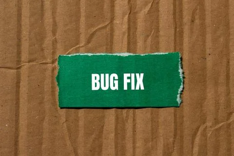 Bug fix message written on ripped torn green paper piece with cardboard backg Stock Photos