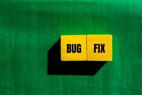 Bug fix message written on yellow wooden cubes with green background. Concept Stock-Fotos