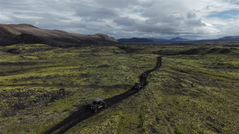 Buggy Convoy Driving through Lava Field Iceland Drone View Video stock 324036704