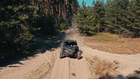 Buggy is going with big clouds of dust. Top view from drone onto race Stock Footage 136156002