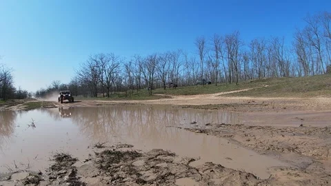 Buggy rides at high speed through 3 puddles in the forest Stock Footage 159469071
